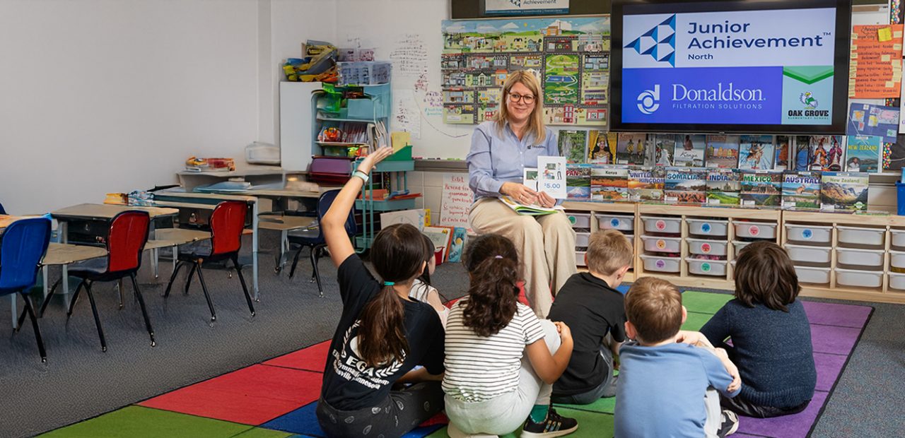 Teacher reading to group of students.