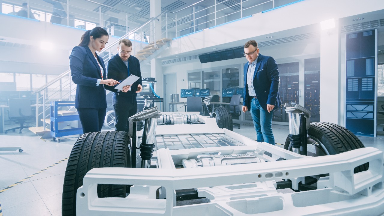 Engineers examine an EV chassis