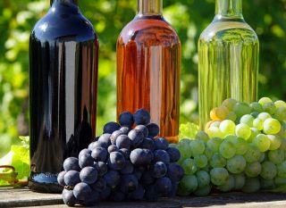 Fotografía de archivo: Fotolia_44977462_X.jpg Botellas de vino Uvas al aire libre sobre una mesa