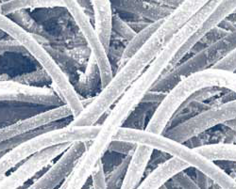 Ces clichés d’un support à manches  utilisé dans un dépoussiéreur filtrant des cendres volantes ont été prises à l’aide d’un microscope électronique à balayage. Les manches  ont été retirés après 2 700 heures d’exploitation. Le ratio de l’air sur le support était de 4,5 à 1. La perte de charge relevée après 2 700 heures d’exploitation est de 152,4 mm (6 po) sur les manches  en polyester et de 50,8 mm (2 po) sur les manches  hydro-enchevêtrés.