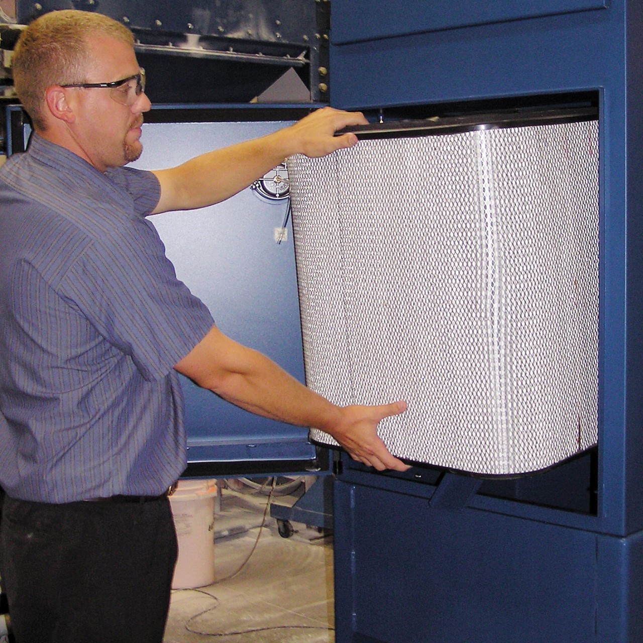 Un homme change le filtre d'un collecteur de brouillard WSO